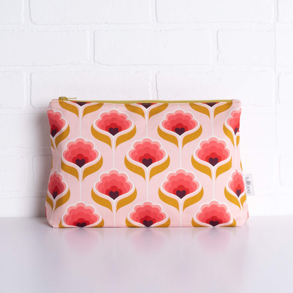 tullibee mini margot retro floral maxi pouch in front of a white brick wall (front view)