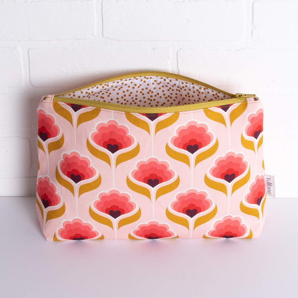 tullibee mini margot retro floral maxi pouch in front of a white brick wall with zip top open & view of mustard spot lining
