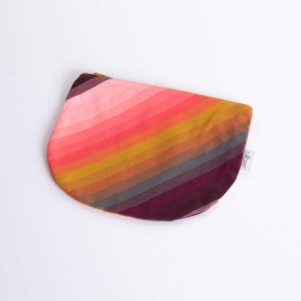 tullibee agnes tonal diagonal stripe midi round pouch at an angle flat on a white surface