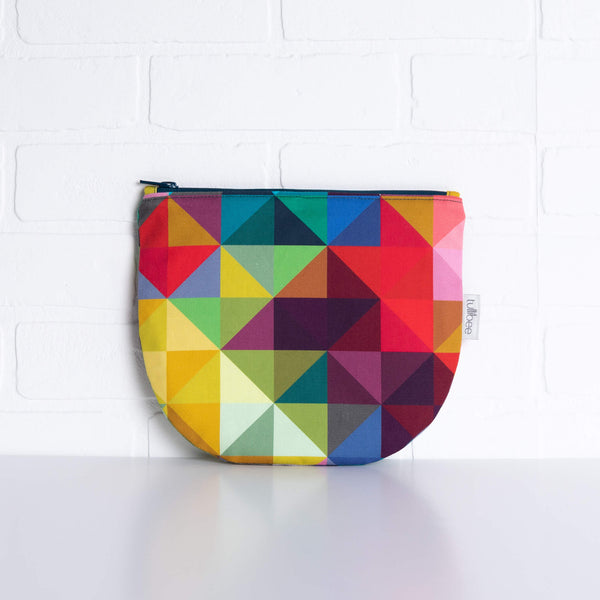 tullibee jules rainbow geometric triangle midi round pouch propped against a white brick wall (front view)