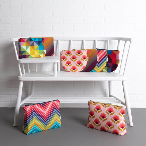 tullibee pouches midi, midi round & maxi sizes all fabric designs on a white ercol telephone bench along in front of a white brick wall